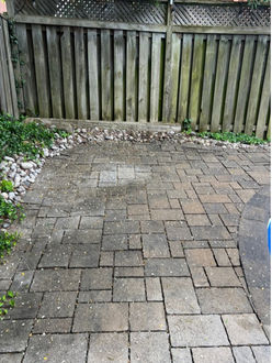 Interlock patio before re leveling in Oakville Ontario showing shifted pavers joint failure and weed growth between stones