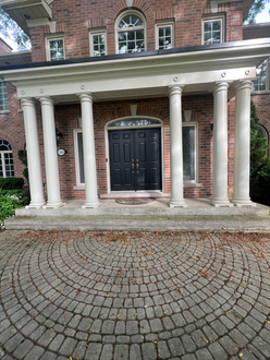 Interlock front entrance before polymeric sanding in Oakville Ontario showing joint erosion debris buildup and early weed growth in paver joints