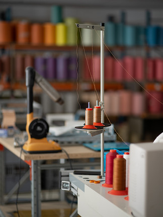 dans une usine de fabrication de maroquinerie française, on voit l'atelier de couture avec dans le fond des tissus et cuir recyclés colorés