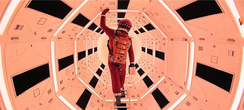 Dr. Dave Bowman (Keir Dullea) wanders down a space station corridor, whose symmetric design and patterns are a hallmark of Stanley Kubrick’s films. Image courtesy of IMDb.com.