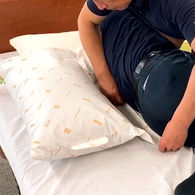 RM2-Hのフラップを敷き込み、側臥位(横向き)のポジショニングサポート例。製品詳細ページへのリンク。