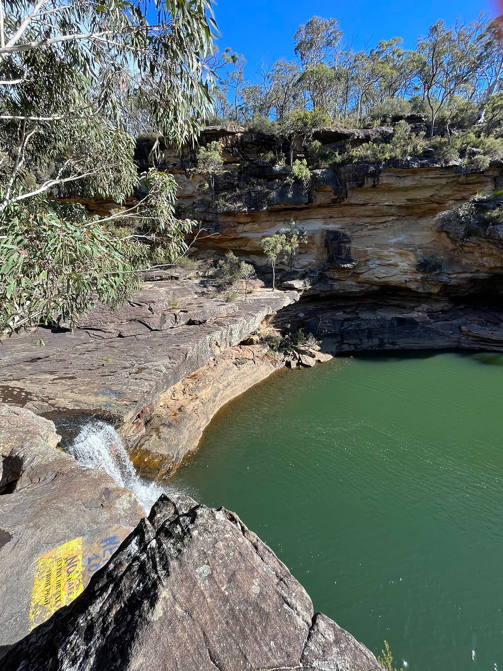 A waterholw with waterfall and cliffs