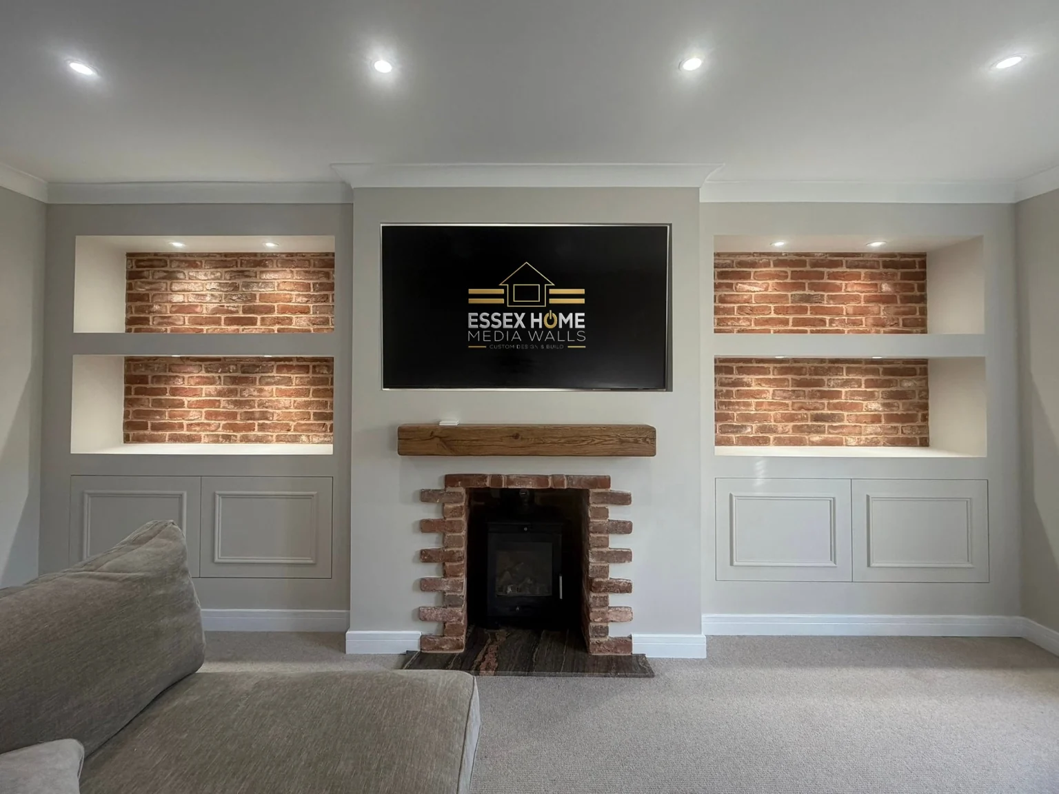 Media wall with brick-effect alcoves, cupboards and a TV above an existing fireplace