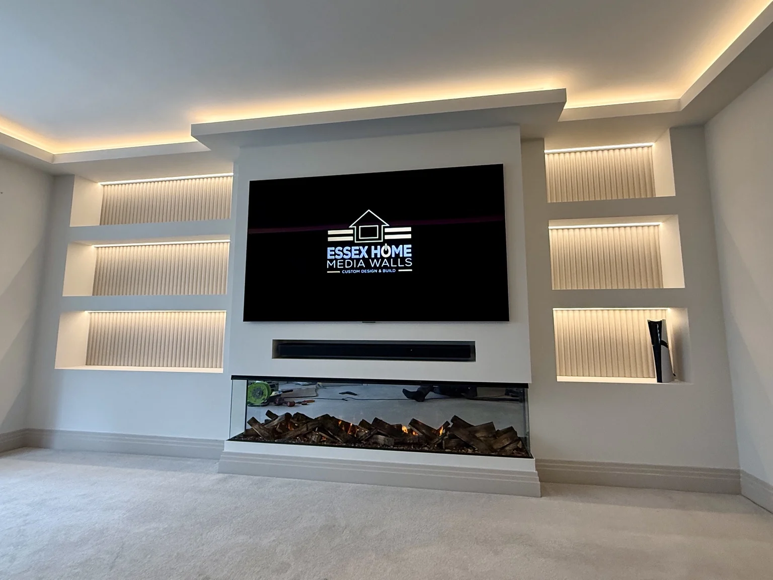 White media wall with illuminated ribbed niches and ceiling cove lighting