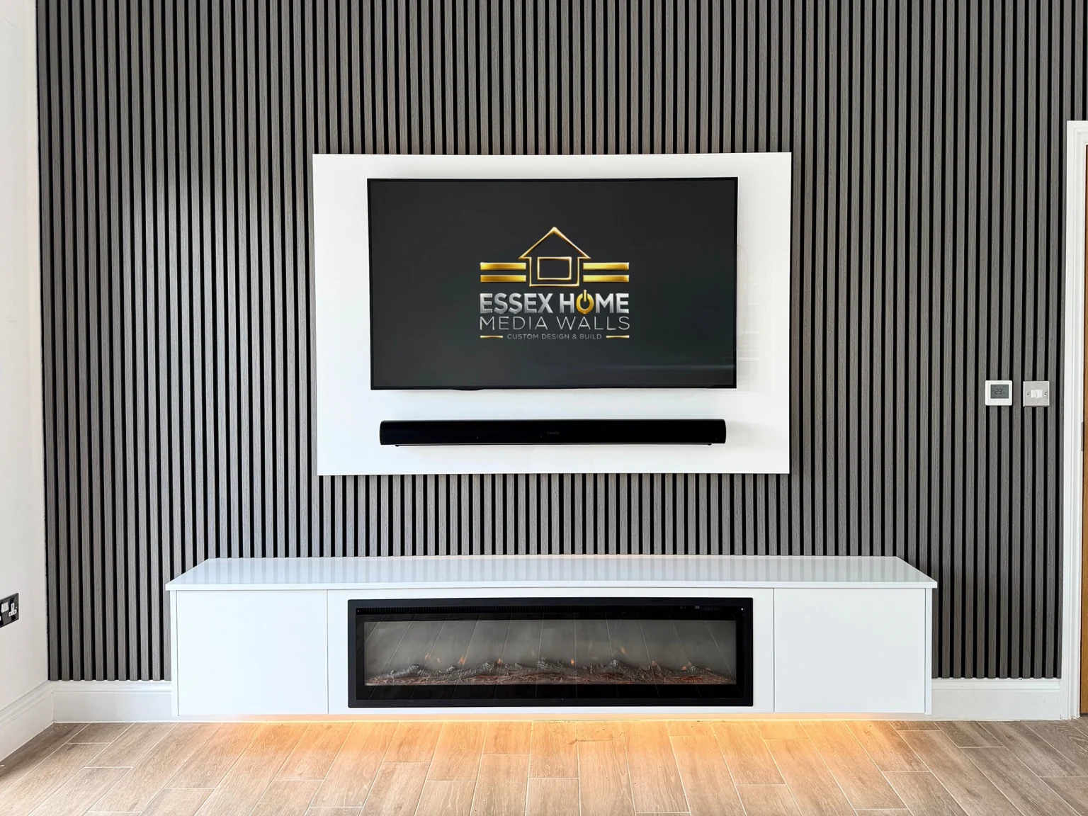 Dark slatted wall with a pale TV surround and low electric fire cabinet
