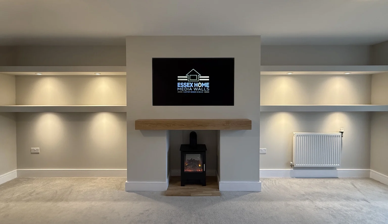 TV chimney feature with illuminated alcove shelves around an existing stove