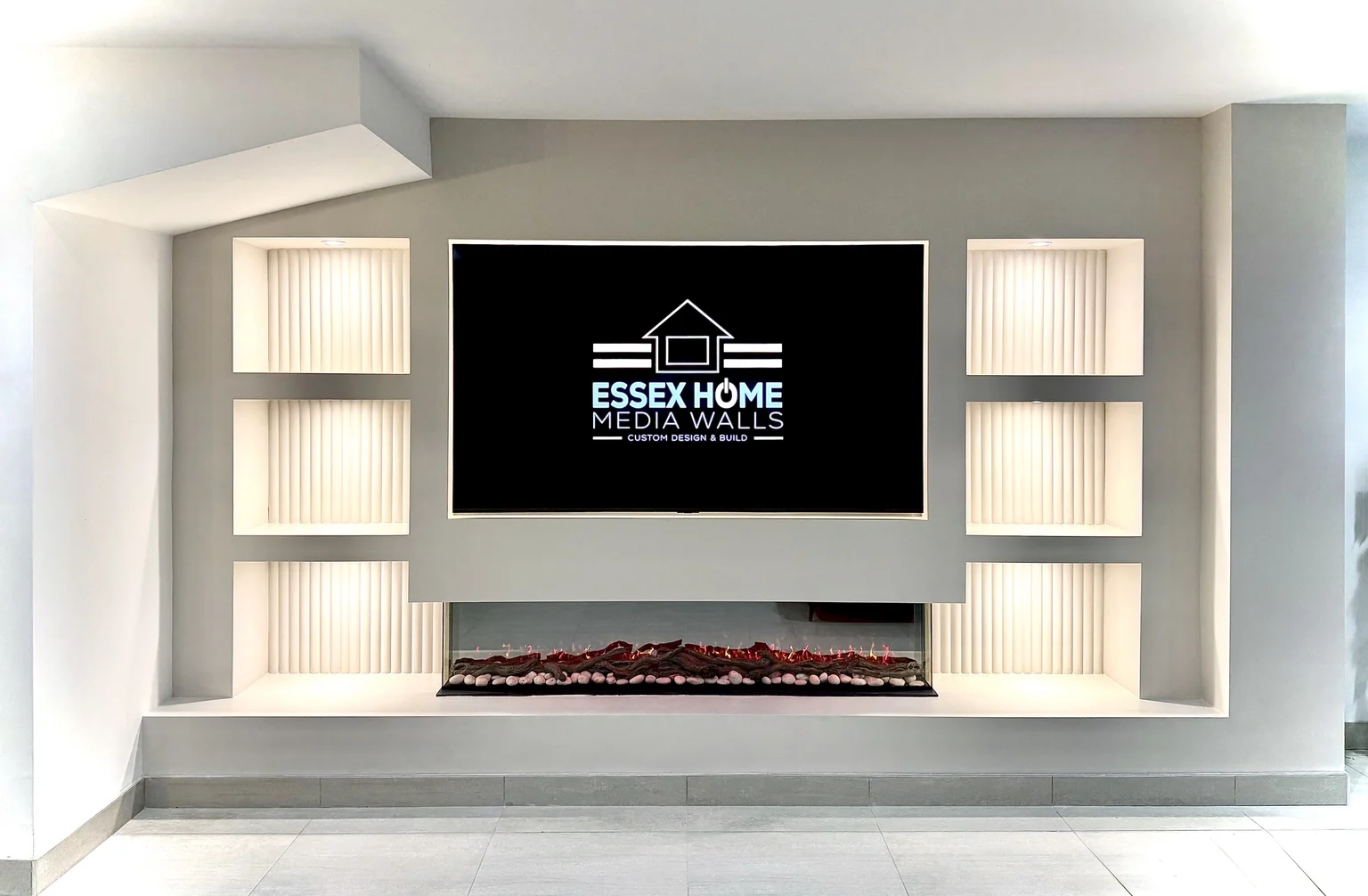 White media wall with narrow ribbed niches and a wide electric fire