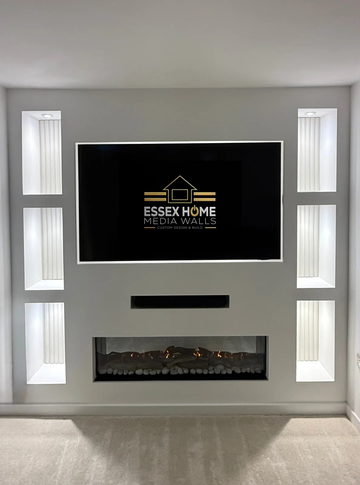 White media wall with slim illuminated niches and an electric fire