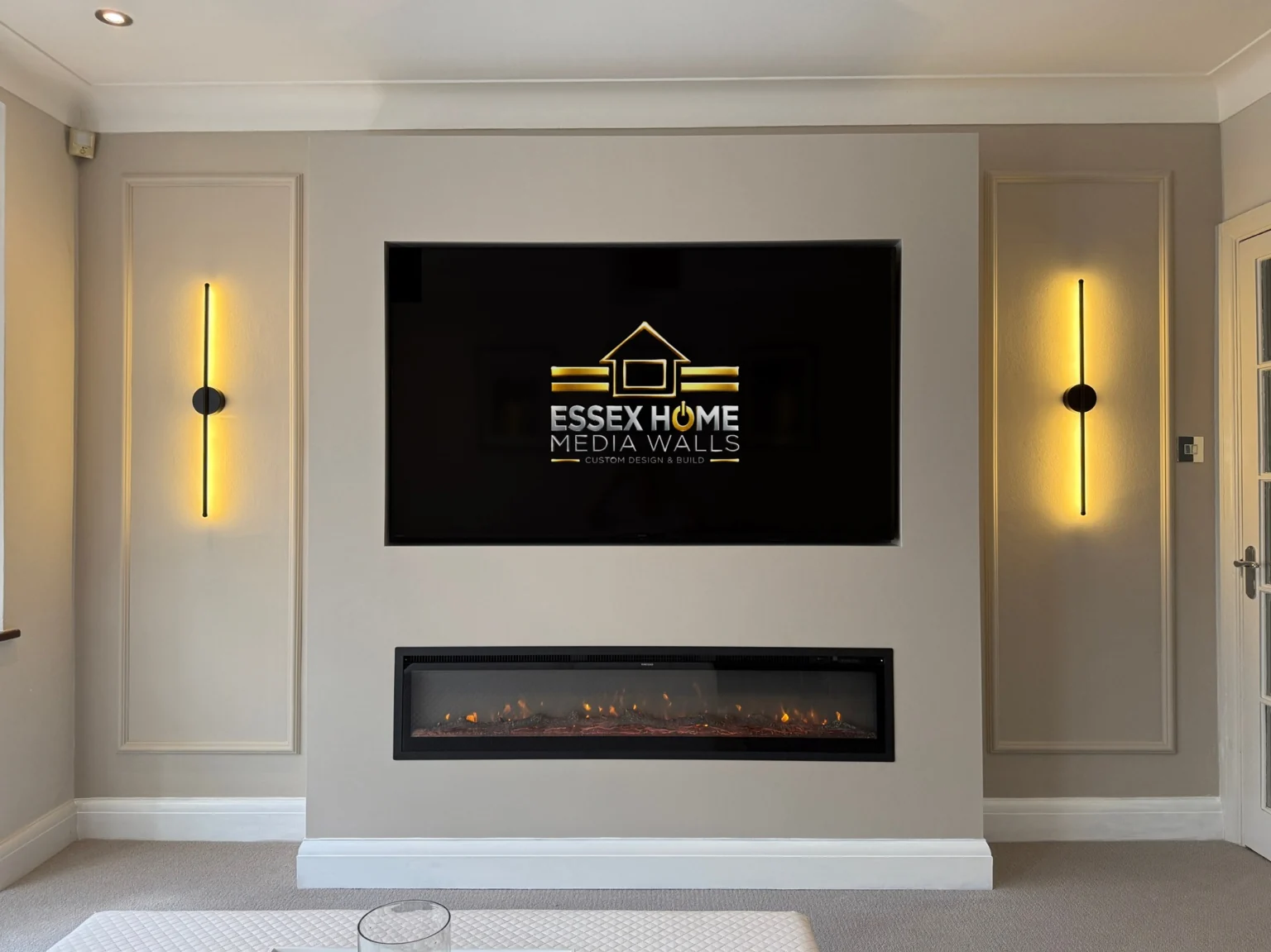 Pale media wall with decorative mouldings and vertical wall lights
