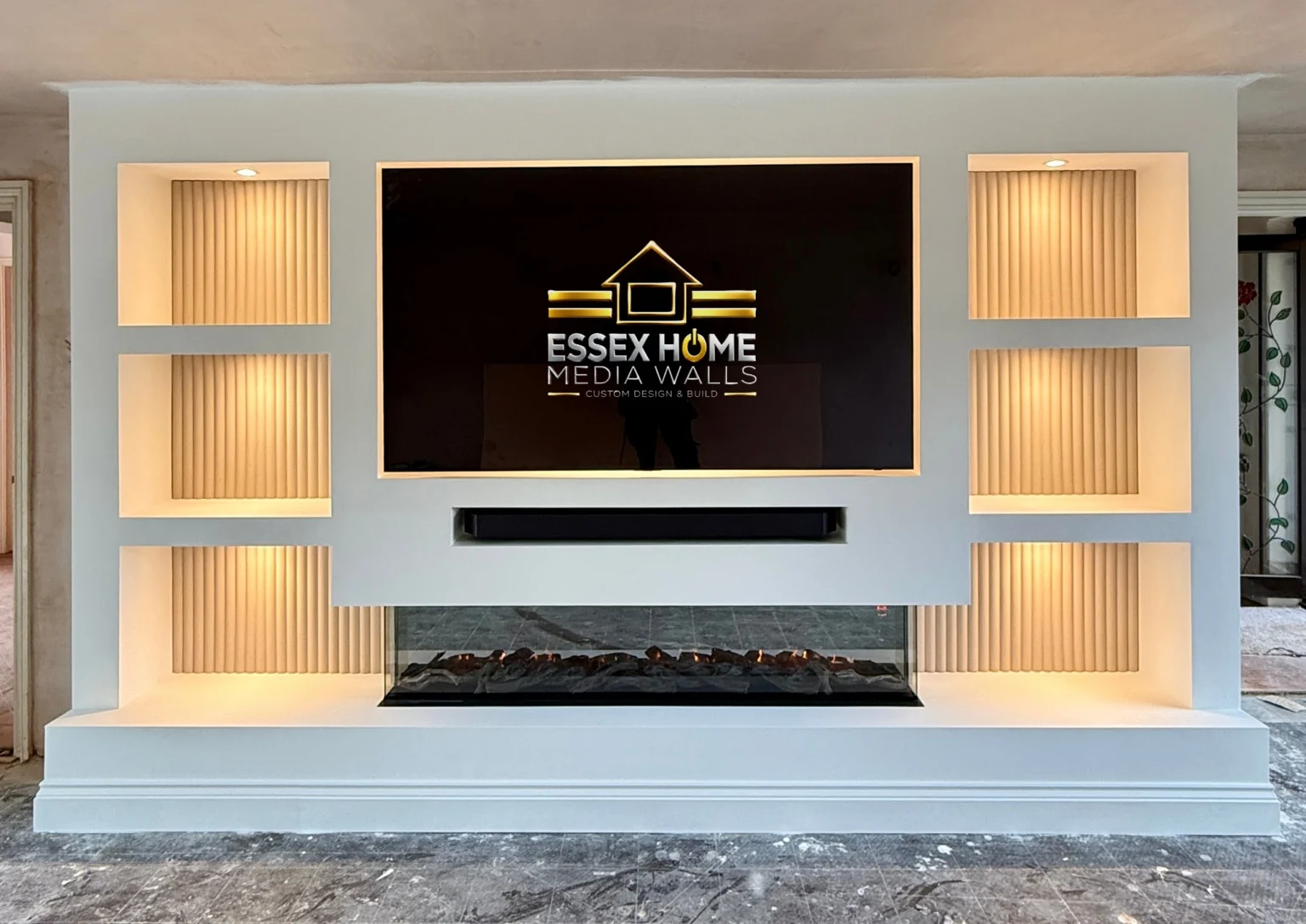 White media wall with warm-lit ribbed niches and a wide low hearth