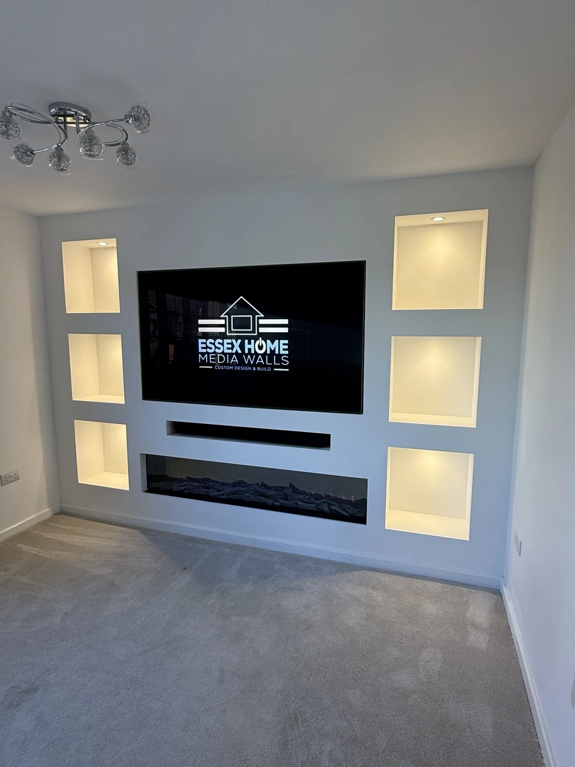 Compact white media wall with six lit display niches and an electric fire