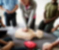Hands-on CPR training with participants practicing chest compressions on an adult manikin during a First Aid and CPR certification class.