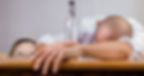 alcoholic parent passed out with empty bottle and child watching