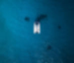 Aerial view of a yacht sailing in crystal-clear waters