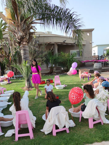 יוםהולדת ספא כל הבנות יושבות על כיסאות עם חלוקי ספא וגיגיות מתפנקות בספא שירני מפנק