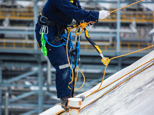 man on roof with abseiling ropes working