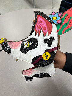 cardboard manipulated to create a fantasy dog with movable mouth