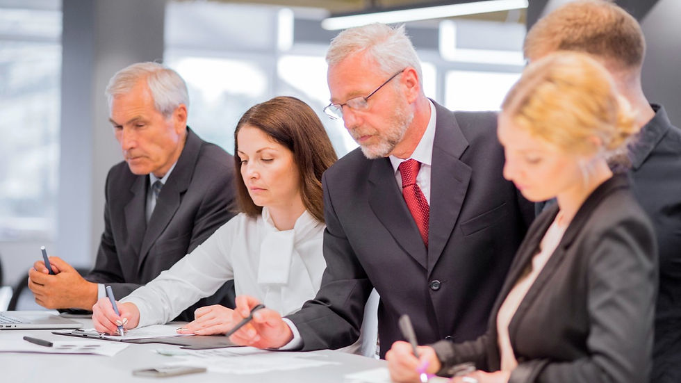 Four people in suits looking serious.