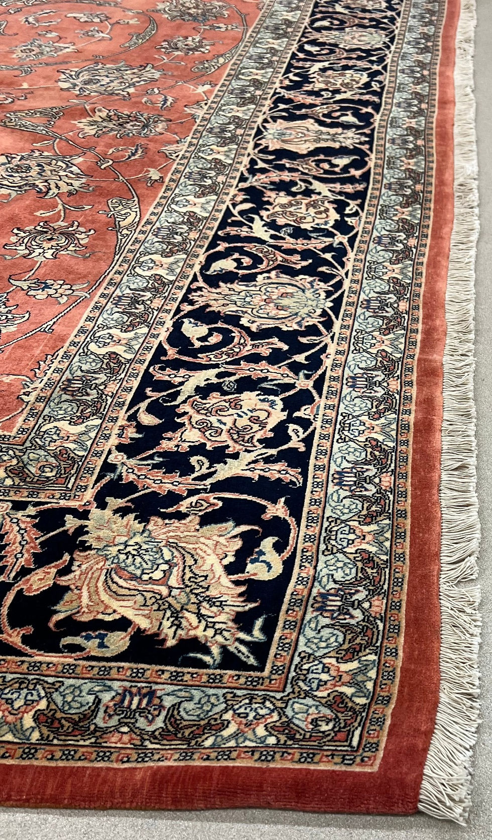 Persian Tabriz rug. This Persian rug features an elegant floral pattern on a red background and blue borders.