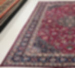 Thumbnail: This Persian rug features a beautifully detailed pattern on a ruby red background, indigo blue borders.