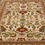 Thumbnail: This Persian rug features an elegant floral design on a cream background and tan borders.