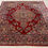 Thumbnail: This Persian rug features a striking medallion motif with florals on a red background.