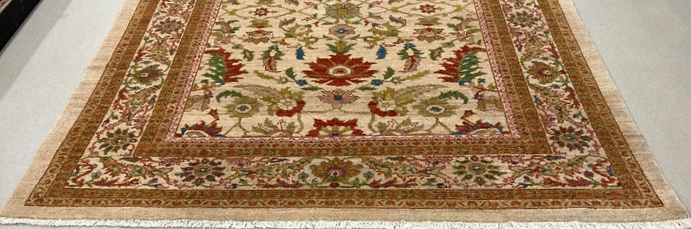 Thumbnail: This Persian rug features an elegant floral design on a cream background and tan borders.