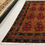 Thumbnail: This Afghan rug features a stunning floral design, cognac background, and green borders.