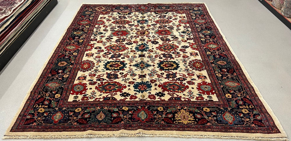 This Persian rug features a beautiful floral design on ivory , dark borders.