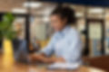 vista-lateral-de-uma-mulher-sorridente-trabalhando-com-um-laptop-no-escritorio.jpg