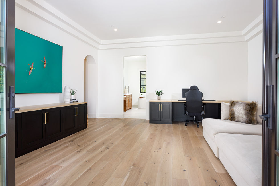 a living room with hardwood floors and a desk with a computer on it