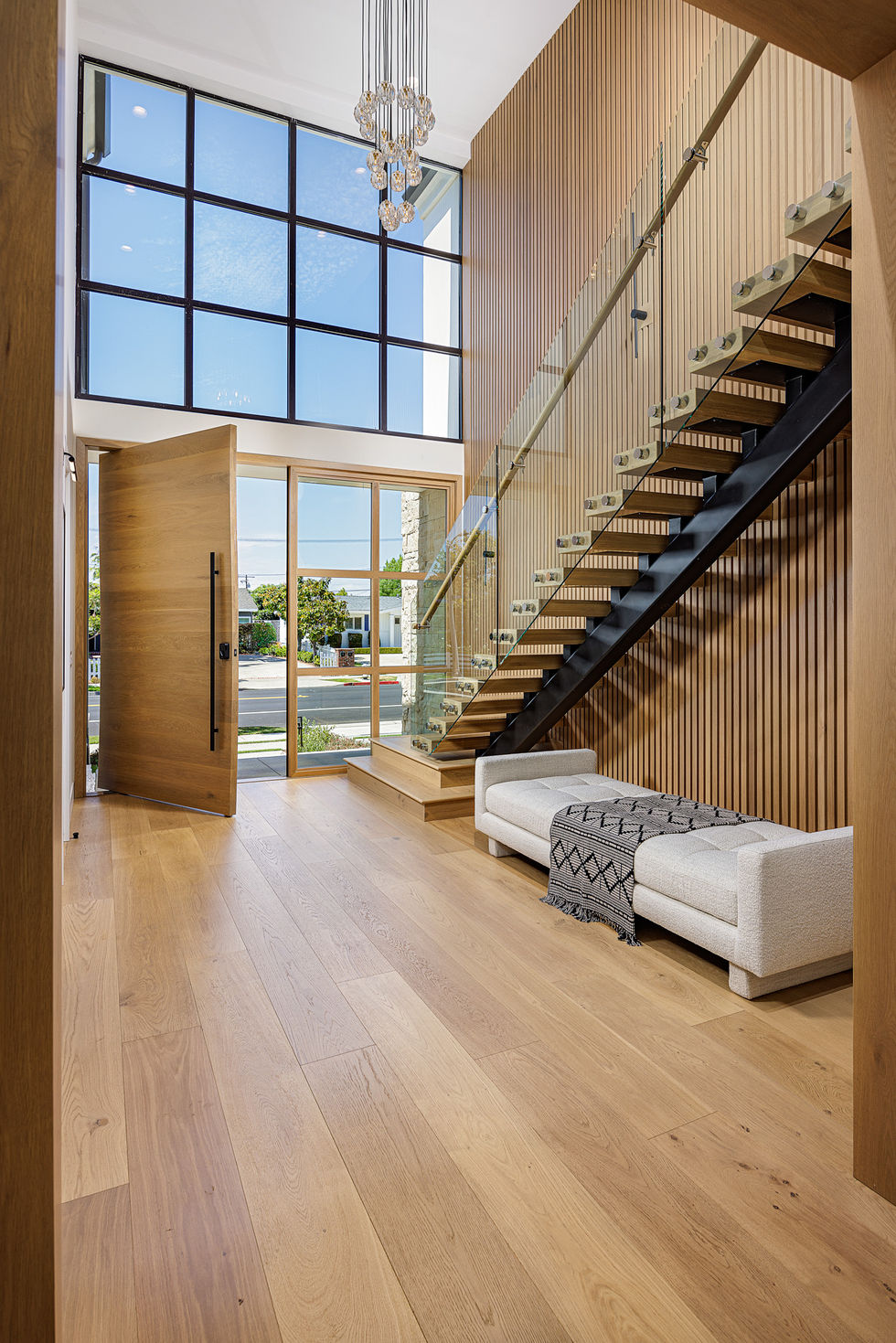 a staircase with a glass railing and a couch in front of it