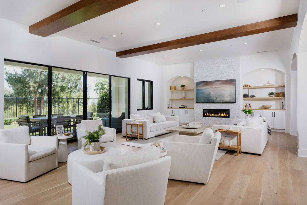 a living room with white furniture and a fireplace