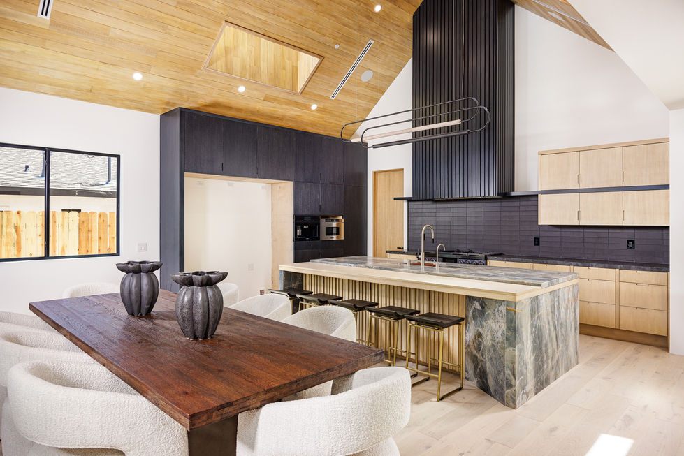 a kitchen with a large island and a wooden table