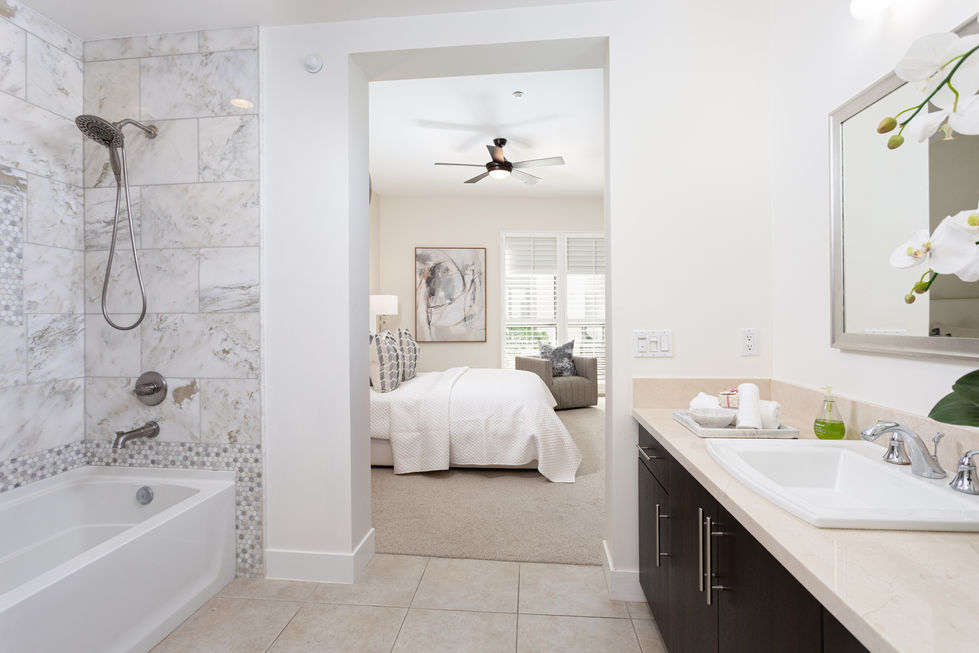 a bedroom with a ceiling fan and a painting on the wall