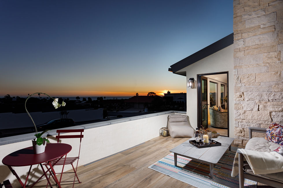 a balcony with a view of the ocean at sunset