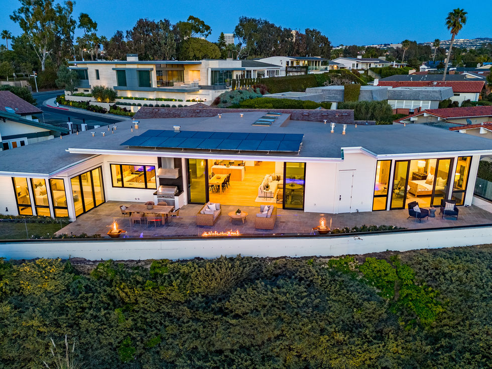 an aerial view of a house with solar panels on the roof