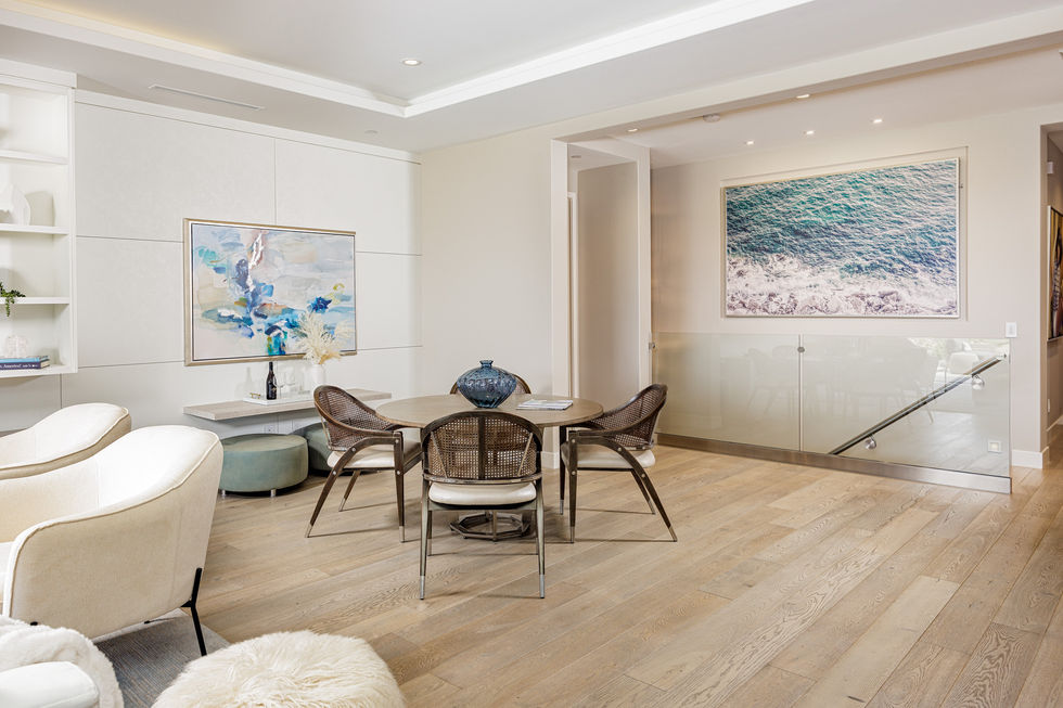 a room with a table and chairs and a painting on the wall