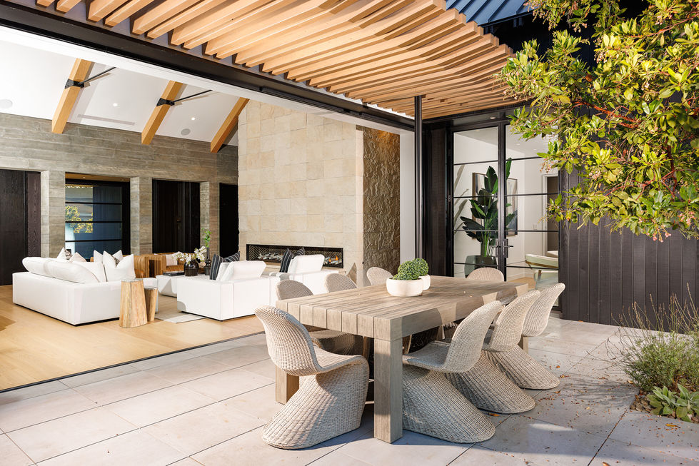 a wooden table with wicker chairs in front of a living room