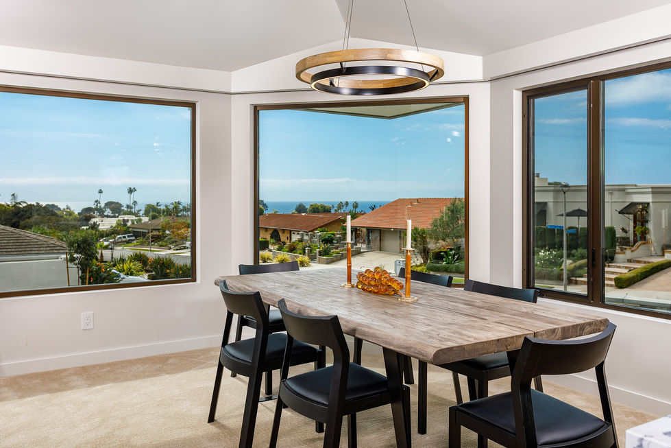 a dining room table and chairs with a view of the ocean