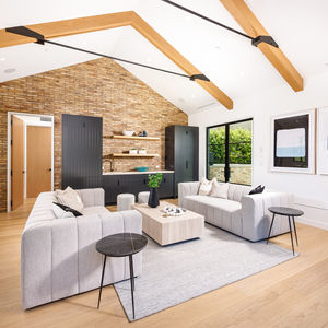 Modern living room with bar high ceilings and beams with brick wall