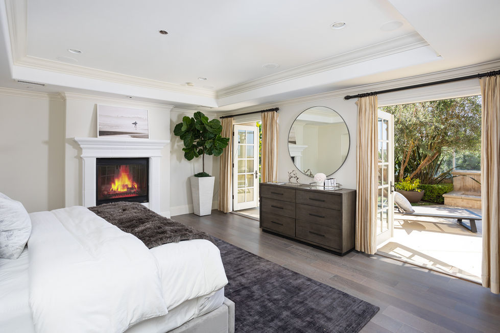 a bedroom with a fireplace and a round mirror