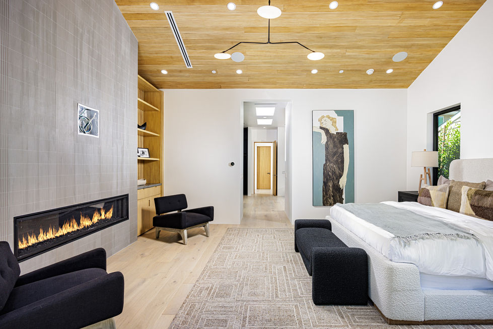 a bedroom with a fireplace and a painting on the wall