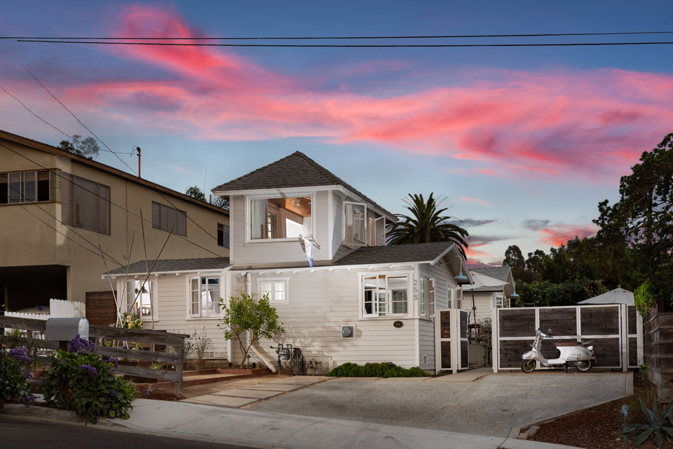 a white house with a pink sky in the background
