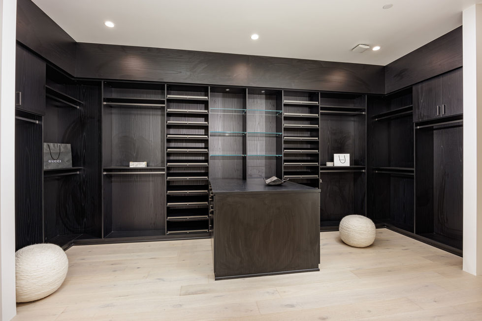a walk in closet with lots of shelves and drawers