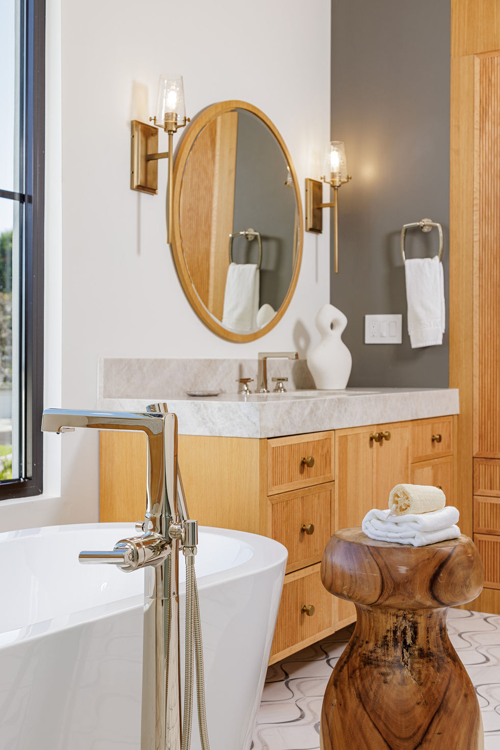 a bathroom with two sinks and a round mirror
