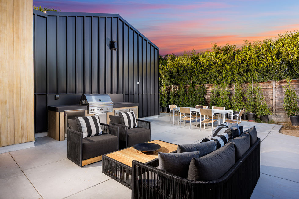 a patio area with a grill and a table and chairs