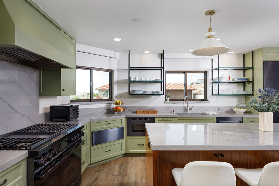 a kitchen with green cabinets and white counter tops