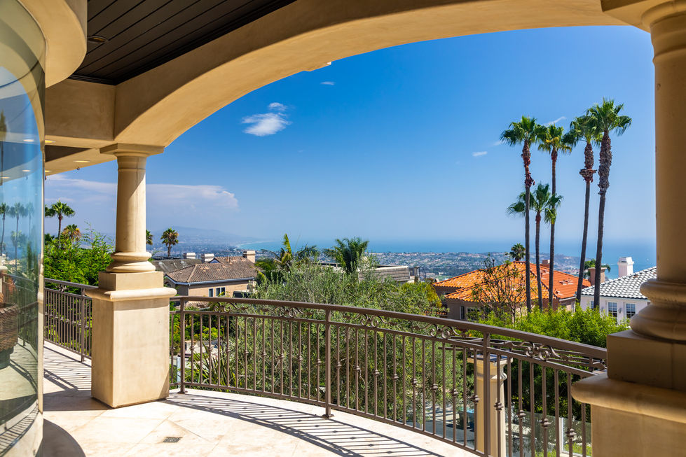 a balcony with a view of a city and the ocean