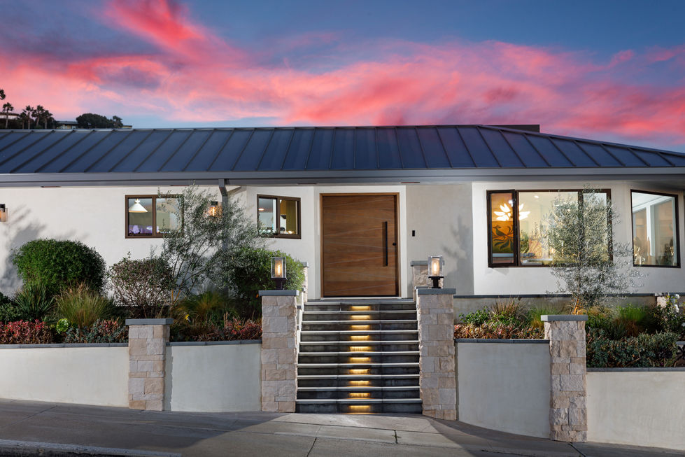 a white house with a black roof and a wooden door